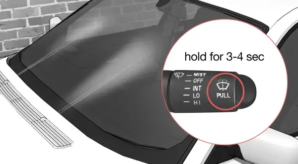 Le levier de commande des essuie-glaces de voiture montre le symbole "PULL" pour activer le lave-glace.