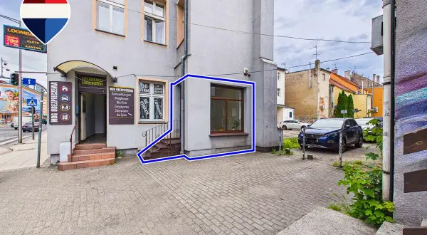 Budynek z wejściem do biura ubezpieczeń i oknem, zaznaczony niebieską ramką.