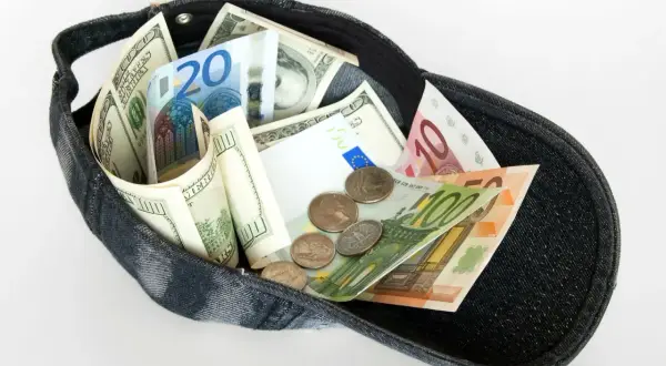 Dolarów i euro w czapce, jakby to był cały majątek z zagranicznego konta bankowego.