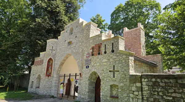 Kamienny, zabytkowy wjazd do Puszczy Dulowskiej z figurą świętego i krzyżami.