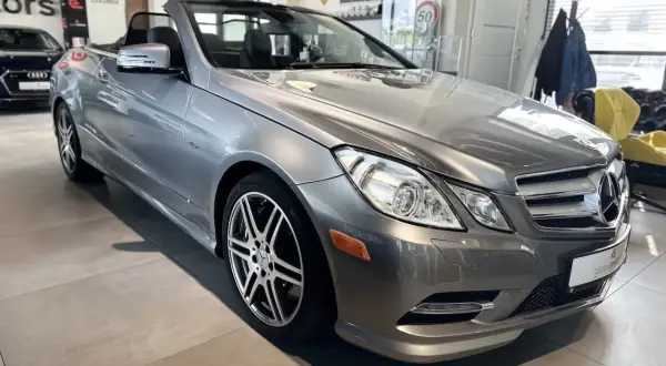 Elegancki, szary kabriolet Mercedes-Benz W207 z opuszczonym dachem, gotowy na letnie przejażdżki.