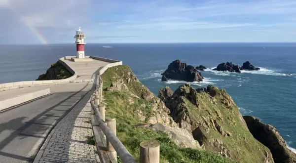 Faro en Cabo Ortegal con arcoíris. Un paisaje espectacular que ver, con el mar azul y rocas escarpadas.