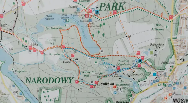 Mapa szlaków turystycznych w Wielkopolskim Parku Narodowym. Widoczne jeziora, lasy, punkty widokowe i zabytki.