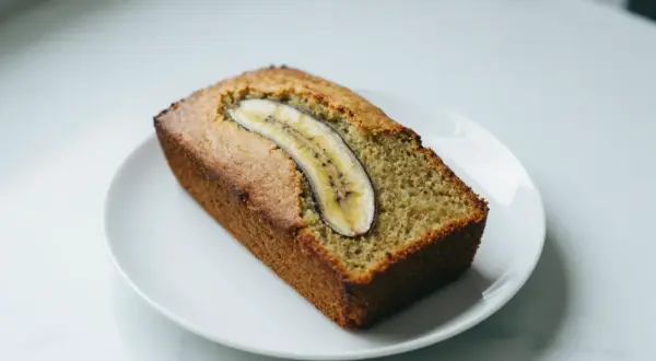 Chlebek bananowy z airfryera, idealnie wypieczony, z plasterkiem banana na wierzchu.