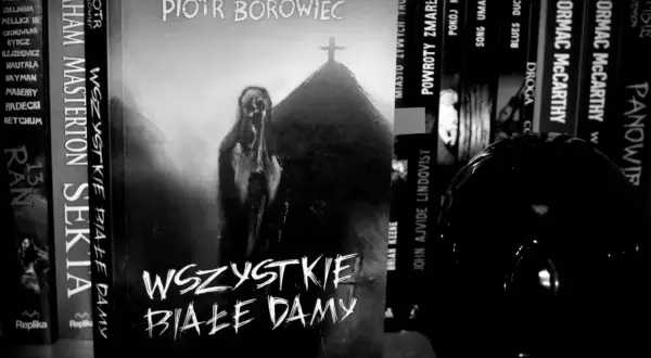Czarno-biała okładka książki "Wszystkie białe damy" Piotra Borowca z postacią i krzyżem.