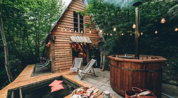 Une cabane dans les arbres dans les Landes, avec un bain nordique fumant et un hamac invitant. Parfait pour une escapade nature.