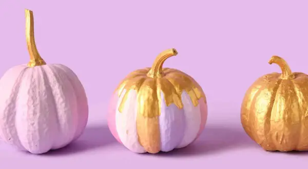 Tre zucche dipinte in tonalità pastello e oro, con un tocco scintillante.
