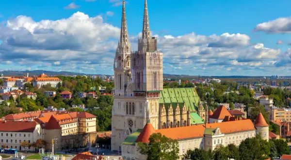 Zagrzeb co zobaczyć: majestatyczna katedra z dwiema wieżami góruje nad miastem, otoczona zabytkową architekturą i zielenią.