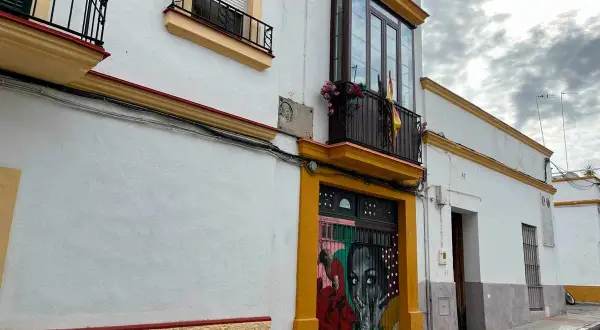 Fachada de la casa Lola Flores en Jerez, con un mural vibrante en la puerta y balcones adornados.