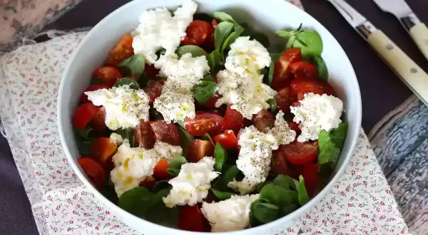 En härlig sallad med tomater, gröna blad och krämig burrata. Perfekt för ett enkelt burrata recept.