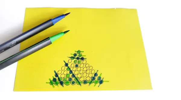Na żółtej kartce narysowana jest gra w ziemniaka. Dwa pisaki, niebieski i zielony, leżą obok.