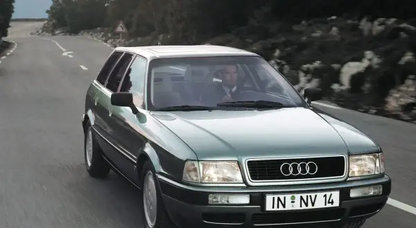 Zielony Audi 1.9 TDI na krętej drodze, kierowca w garniturze.