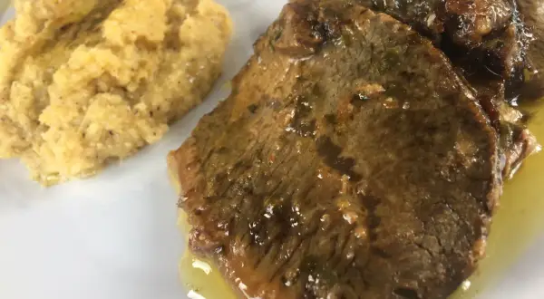 Fette di carne in umido con polenta, un classico della ricetta bresciana.