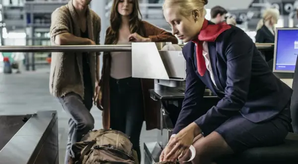 Para sprawdzić, ile bagaż podręczny Ryanair zmieści się w tej ramce, para czeka na odprawę.