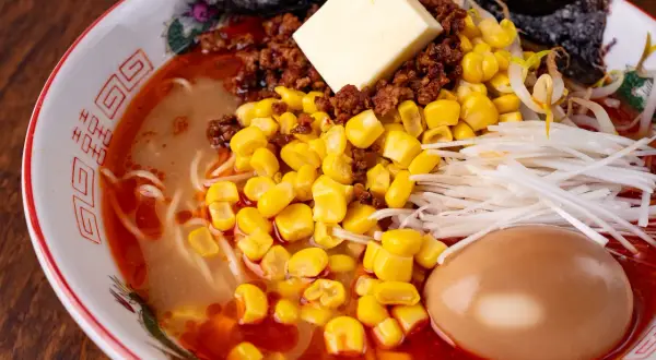 Miseczka zupy ramen z masłem, mielonym mięsem, kukurydzą, szczypiorkiem i jajkiem. Pyszny przepis na ramen jak z MasterChefa!