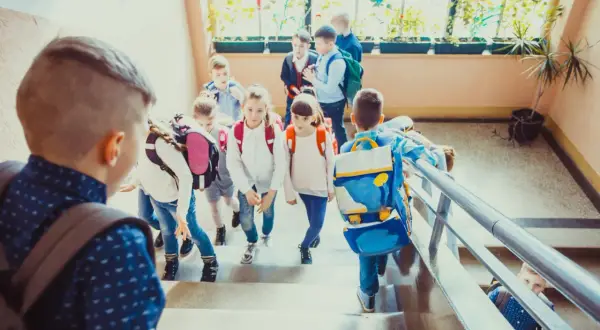 Dzieci z plecakami schodzą po schodach, jakby wracały do domu po lekcjach. Może to dzień, w którym weszła w życie ustawa Kamilka, zapewniająca im bezpieczeństwo.