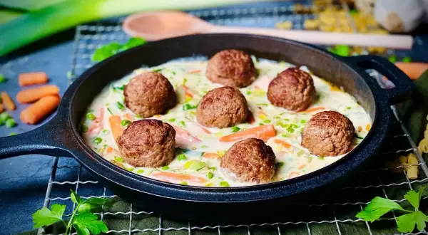 Herzhafte Frikadellen in cremiger Sauce mit Karotten und Erbsen, ein köstliches Wikingertopf Rezept.