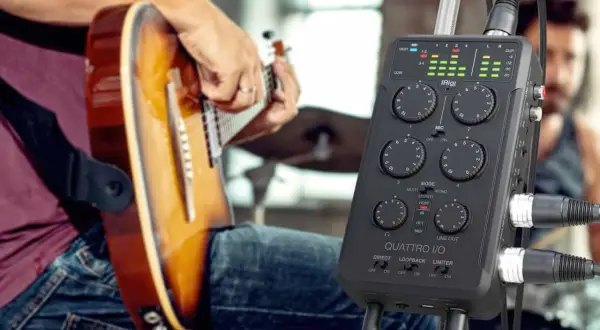 Musiker spielt Gitarre, während ein iRig Quattro I/O bereitsteht, um die Musik aufzunehmen.
