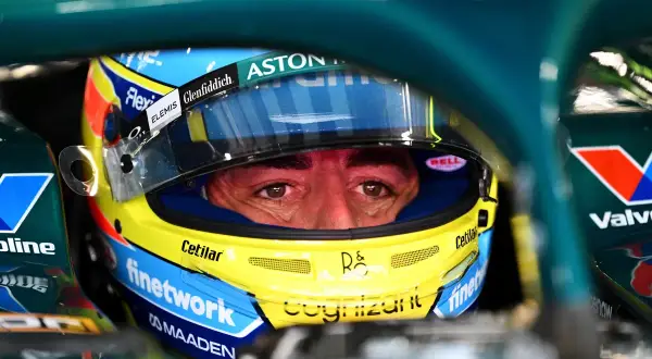 Ojos concentrados de Fernando Alonso con casco Aston Martin, listo para la carrera.
