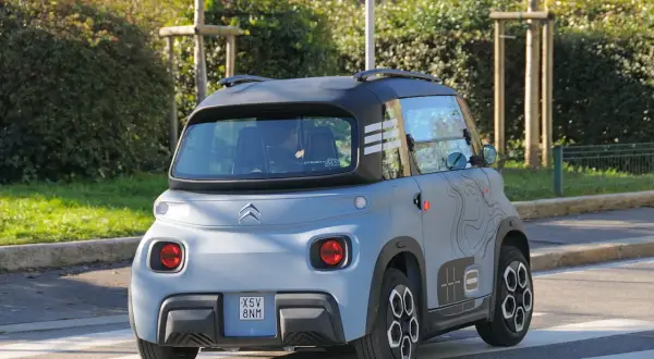 Citroën Ami in prova su strada, vista posteriore. Un veicolo elettrico compatto e originale, ideale per la mobilità urbana.