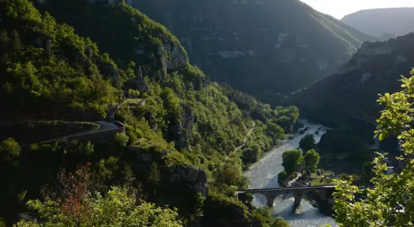La famille Bournazel profite d'une vue spectaculaire sur une vallée verdoyante, une rivière scintillante et un pont de pierre.