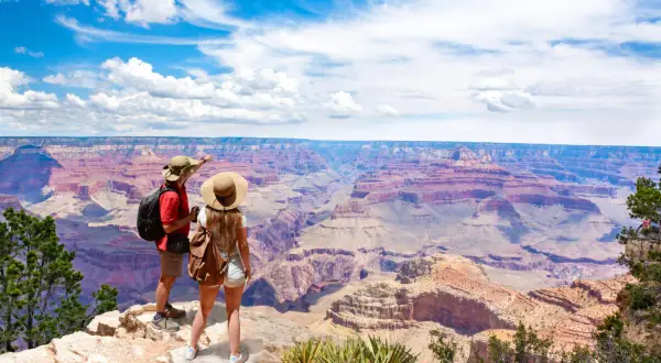 Paar bestaunt Grand Canyon. Tolle USA Reisetipps für unvergessliche Ausblicke und Abenteuer.