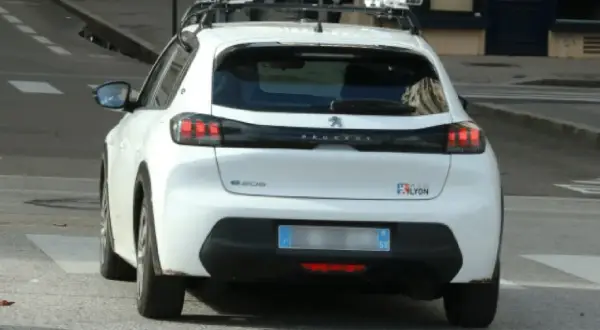Voiture radar privé, équipée de capteurs sur le toit, en fonctionnement dans la ville de Lyon.