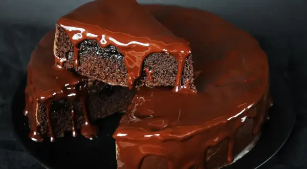 Saftiger Schokokuchen mit glänzender Schokoladenglasur, der wie von Zauberhand im Thermomix entstanden ist.