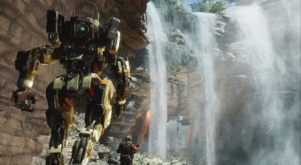Potężny mech z gry Titanfall 3 stoi obok wodospadu, a pilot w skafandrze bojowym wpatruje się w niego.