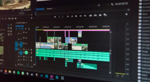 Ekran komputera z programem do edycji wideo. Widoczny jest pasek czasu z klipami wideo i ścieżkami audio, gotowy do montażu.