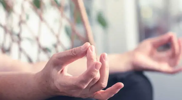 Mains en mudra, pratiquant des exercices de yoga des mains pour la relaxation et la concentration.