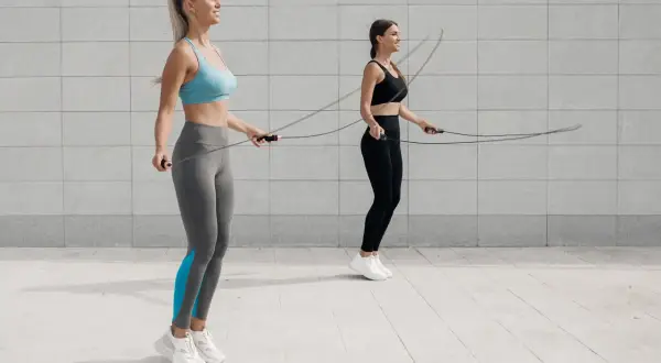 Dwie kobiety ćwiczą z linkami. Idealna skakanka do crossfitu to klucz do efektywnego treningu.