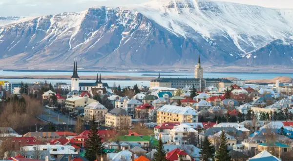 Reykjavik, stolica najbezpieczniejszego kraju w Europie, z kolorowymi dachami i ośnieżonymi górami w tle.