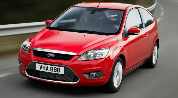 Czerwony Ford Focus MK2 1.6 TDCI w wersji 3-drzwiowej, jadący po zakręcie drogi.