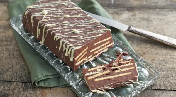 Schokoladenkuchen mit Keksen, ein leckeres rezept kalter hund ohne kokosfett, verziert mit weißer Schokolade.