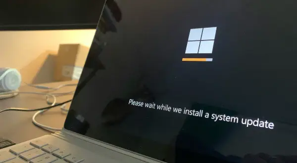 Ekran laptopa z logo Windows i paskiem postępu. System Windows 10 LTSC instaluje aktualizację.