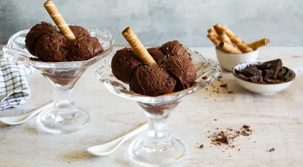 Coppette di granita al cioccolato, guarnite con cialde e scaglie di cioccolato.