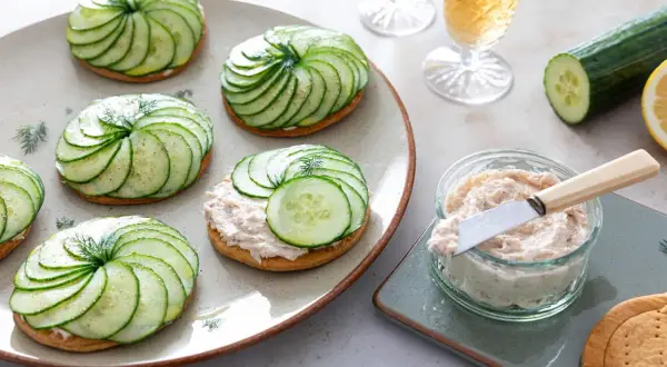 Délicieuses tartelettes salées gastronomiques ornées de fines rondelles de concombre disposées en spirale, garnies d'une touche d'aneth.