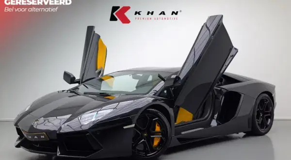 Czarny Lamborghini Aventador z otwartymi drzwiami, żółte akcenty we wnętrzu.