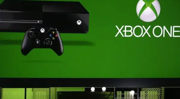 Konsola Xbox One i kontroler na zielonym tle. Premiera Xbox One w 2013 roku.