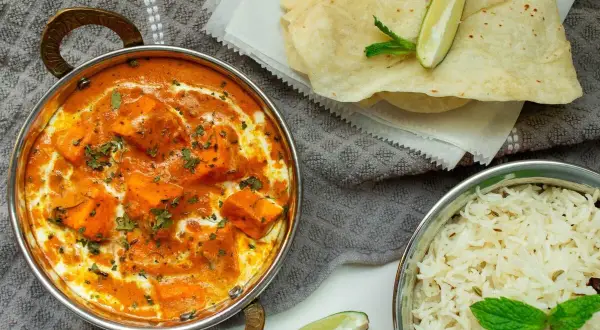 Un cremoso plato de paneer tikka masala, que es el curry, acompañado de arroz basmati y pan naan.