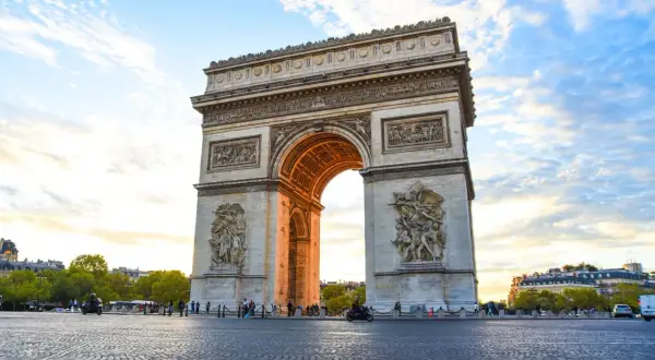 Triumfbågen, en av de mest kända byggnaderna i Paris, reser sig majestätiskt mot en molnig himmel.
