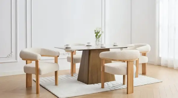 En elegant matplats med olika stolar runt ett modernt matbord. En vas med blommor står på bordet.