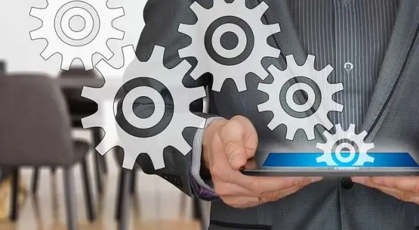 Uomo in giacca e cravatta con ingranaggi che simboleggiano il successo del business online.