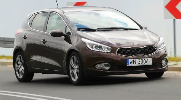 Brązowy Kia Ceed 1.6 CRDi jedzie po drodze.