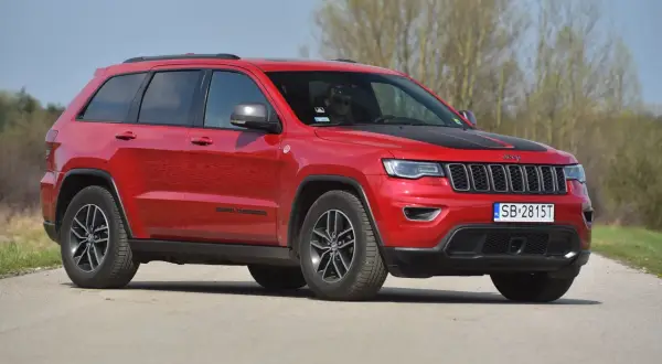 Czerwony Jeep Grand Cherokee na drodze. Poznaj jego imponujące jeep grand cherokee wymiary i możliwości terenowe.