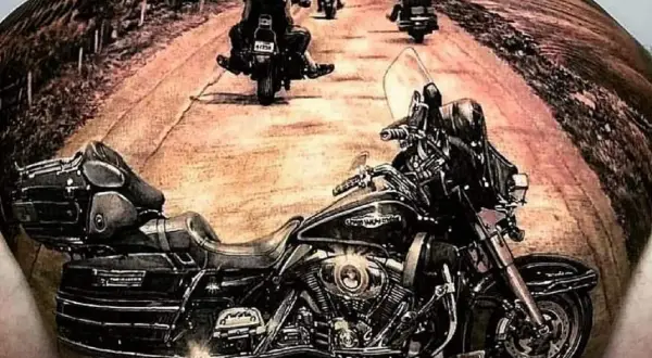 Niesamowite tatuaże motocyklowe: motocykl i grupa motocyklistów na drodze.