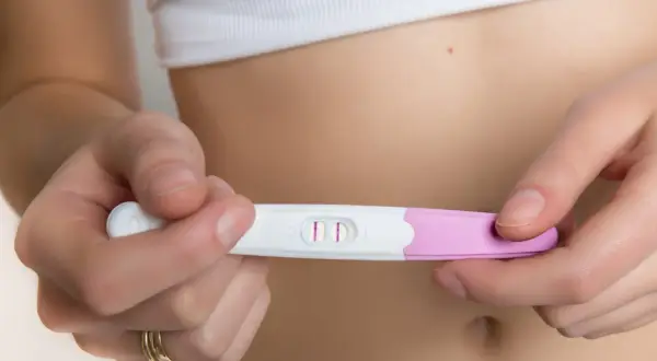 Dwie kreski na teście ciążowym, potwierdzające 4 tydzień ciąży. Objawy mogą być subtelne, ale ten test mówi wszystko.