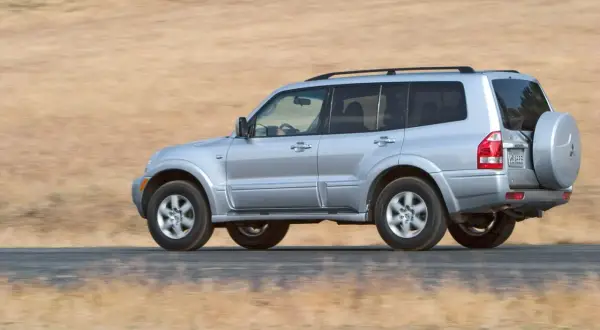 Mitsubishi Montero 3.2 DID off road, plate VM 5666, driving on a dusty road with dry grass background.