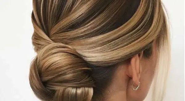 Acconciature capelli medi per cerimonia: un elegante semiraccolto con morbide onde e un chignon basso, perfetto per un look sofisticato.